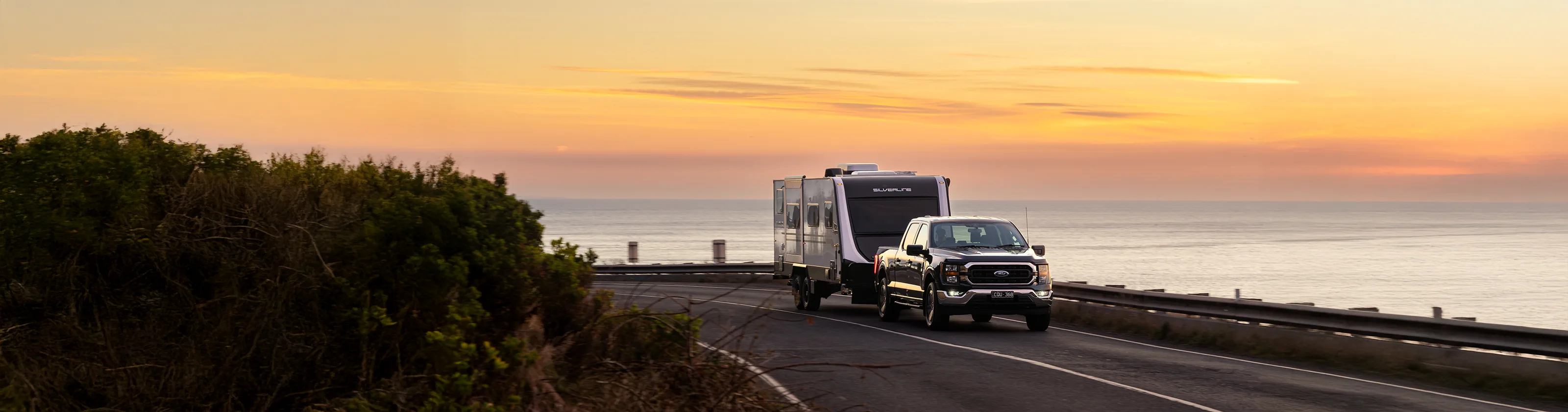 Jayco Silverline caravan on coastal road at sunrise