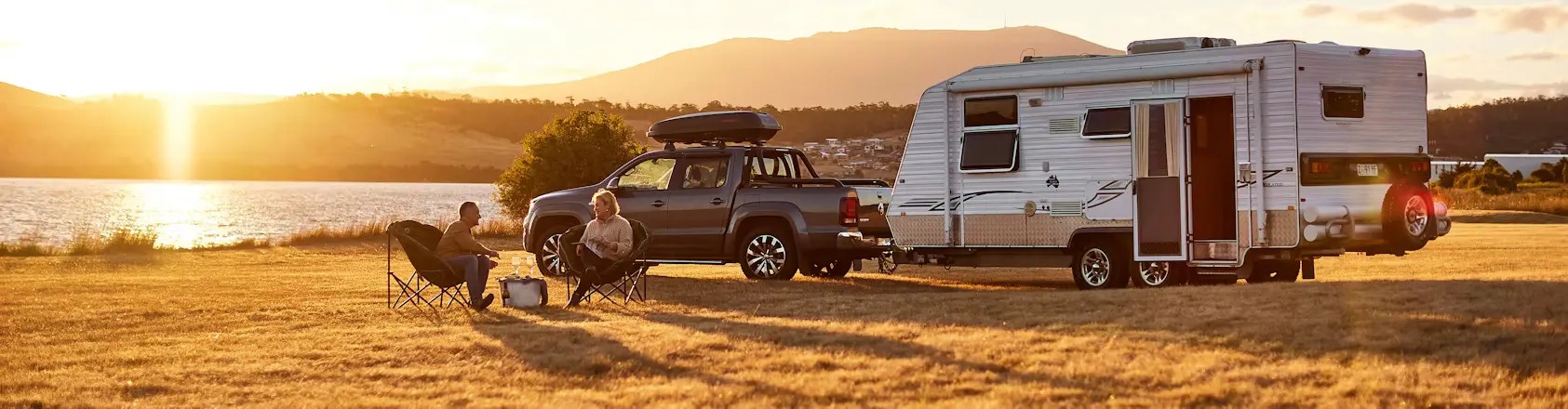 Caravan at camp beside a lake at sunset